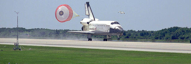 Spaceship landing with parachute behind